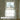 Window with white curtain and gold fixtures in a bathroom setting