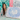 Smiling woman showcasing a canvas with a blue irregular dot pattern, reflecting the Pat Blue designer curtain aesthetic.