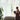 Sheer cream curtains filtering light in a cozy home, a woman looking outside. Window treatments for cozy living.