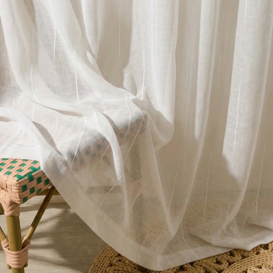 White and Snow, Sheer white curtain draped over a chair with a woven seat