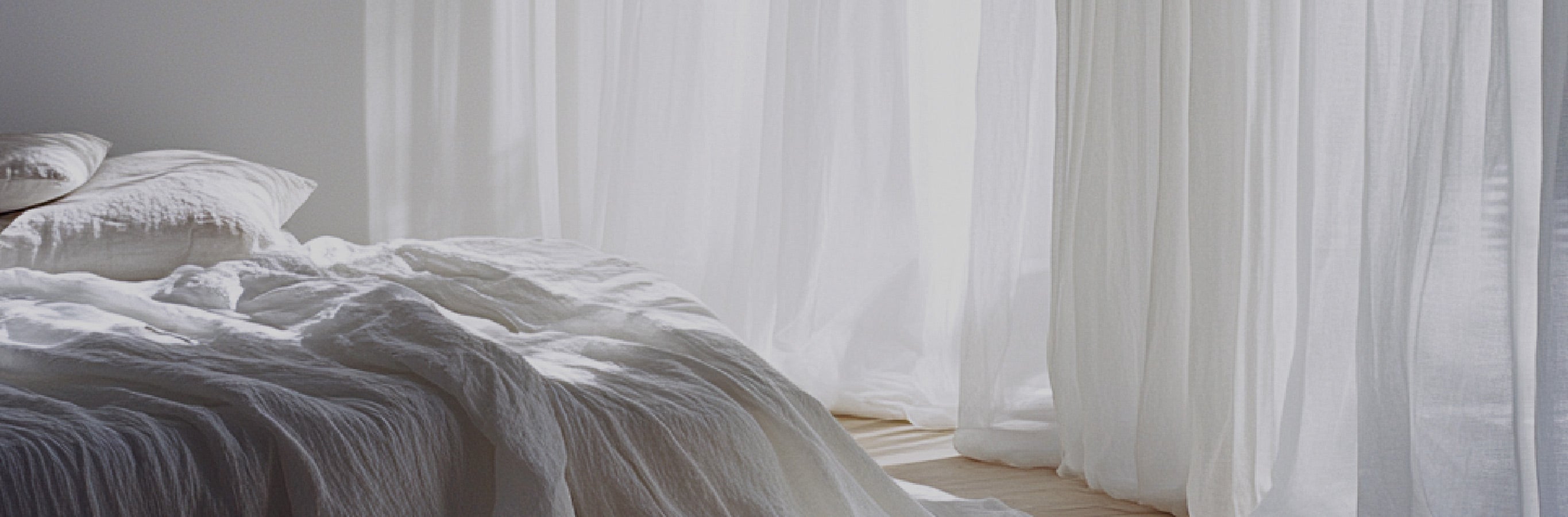 Close-up of Ella Semi Sheer Curtains, showcasing their elegant drape and ability to soften natural light in a cozy bedroom.