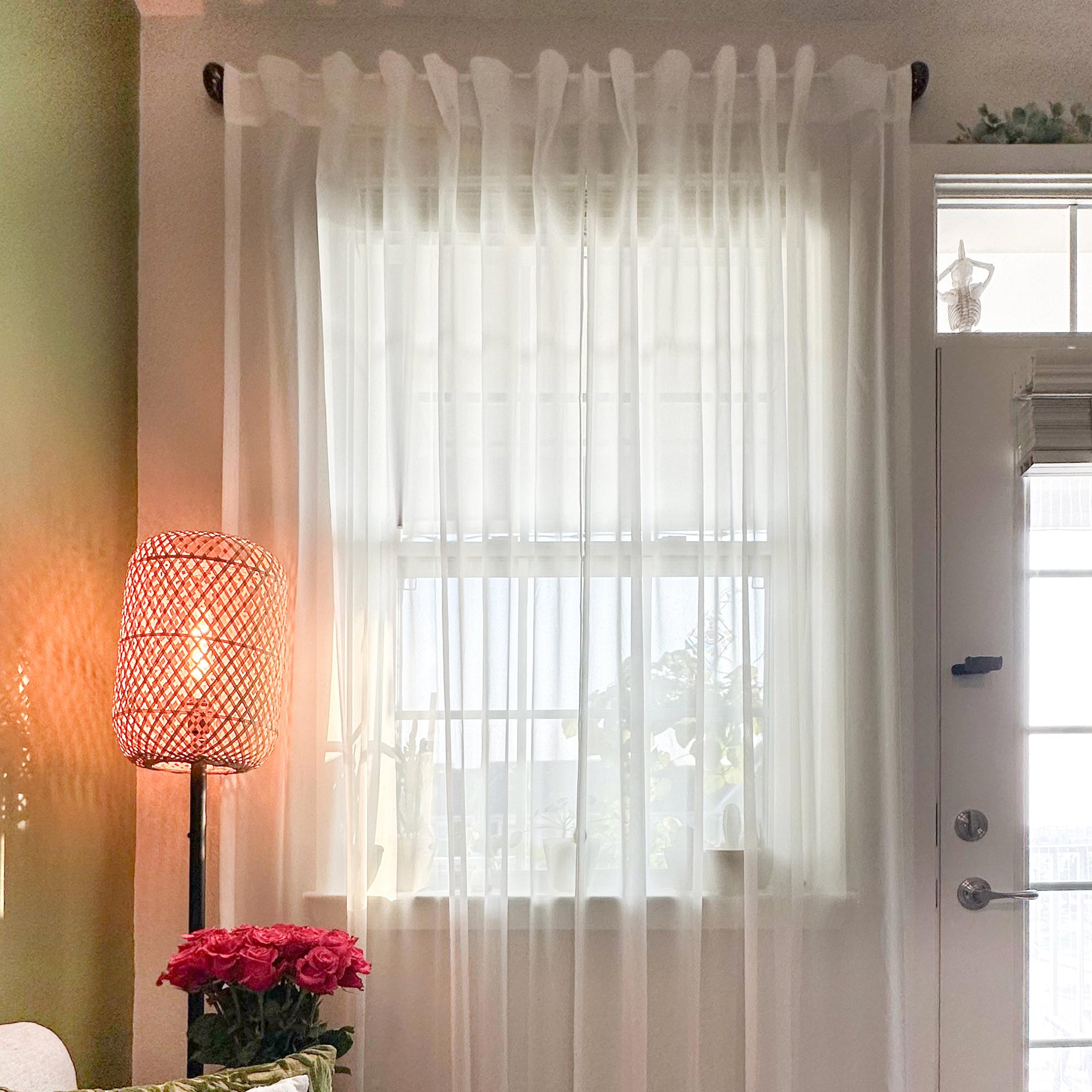 White,Sheer white curtain with a lamp and flowers in a room.