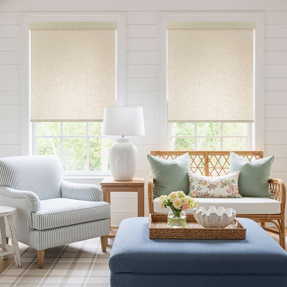 Linen, Living room with linen roller shades, striped armchair, ottoman, and wicker loveseat with floral cushions.