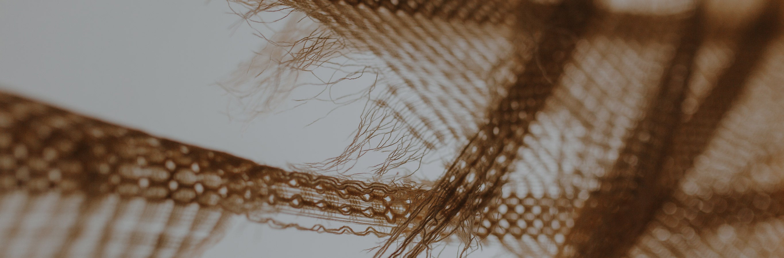 Macro view of Brenda Bohemian Semi Sheer Curtains fabric, showcasing the unique loose weave and fringed details characteristic of boho design.