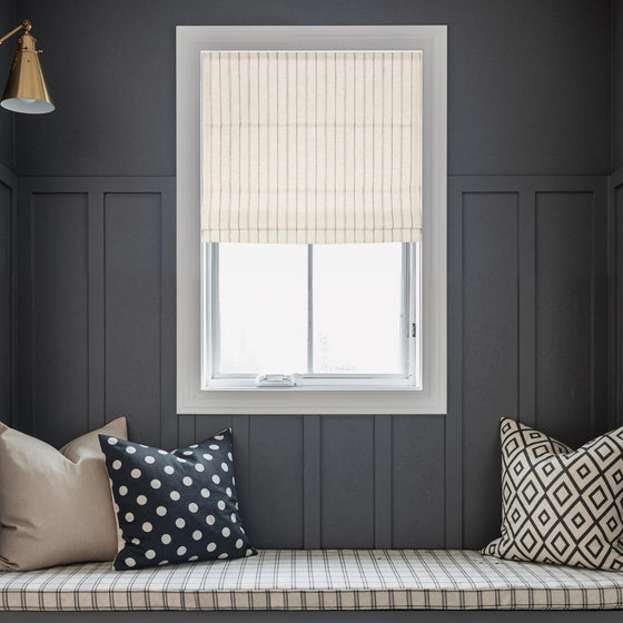 Dark Gray, Window with striped blinds in a room with dark gray walls, a window seat with pillows, and a lamp.