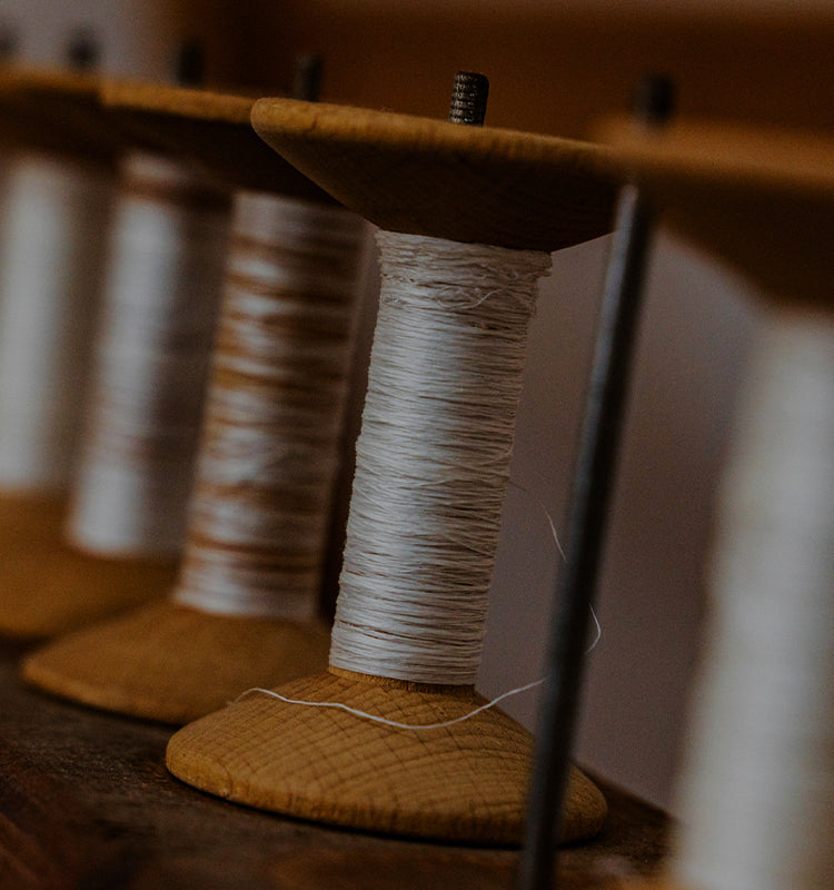 Spools of thread on a wooden reel with a blurred background