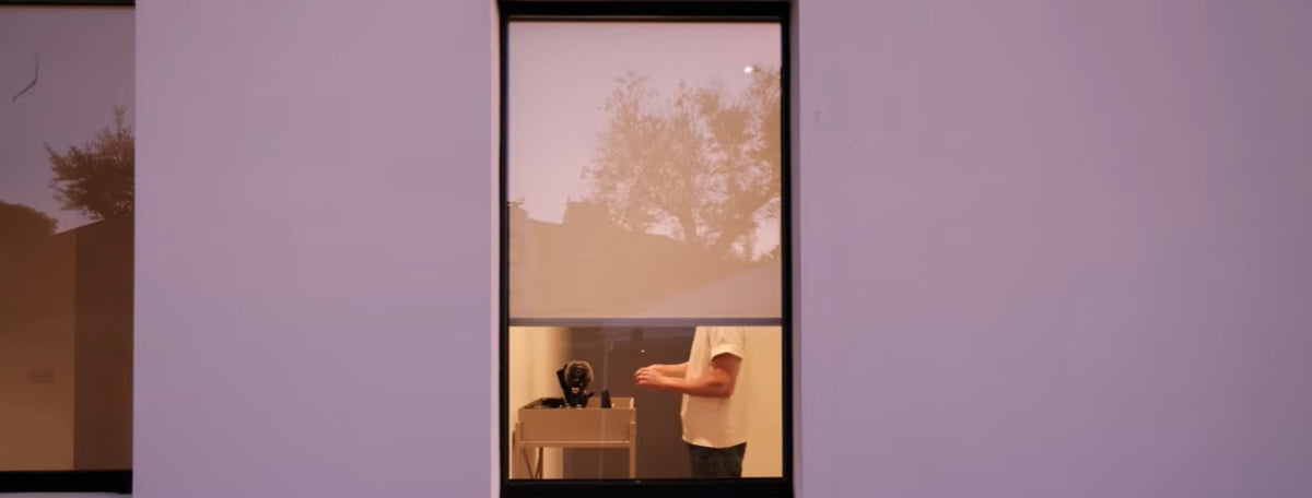 Piper linen roller shade on a street-facing living room window — daylight filtering in while maintaining privacy from outside