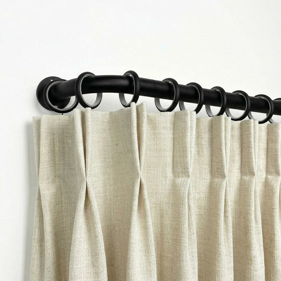 Beige curtains with a black curtain rod on a white background