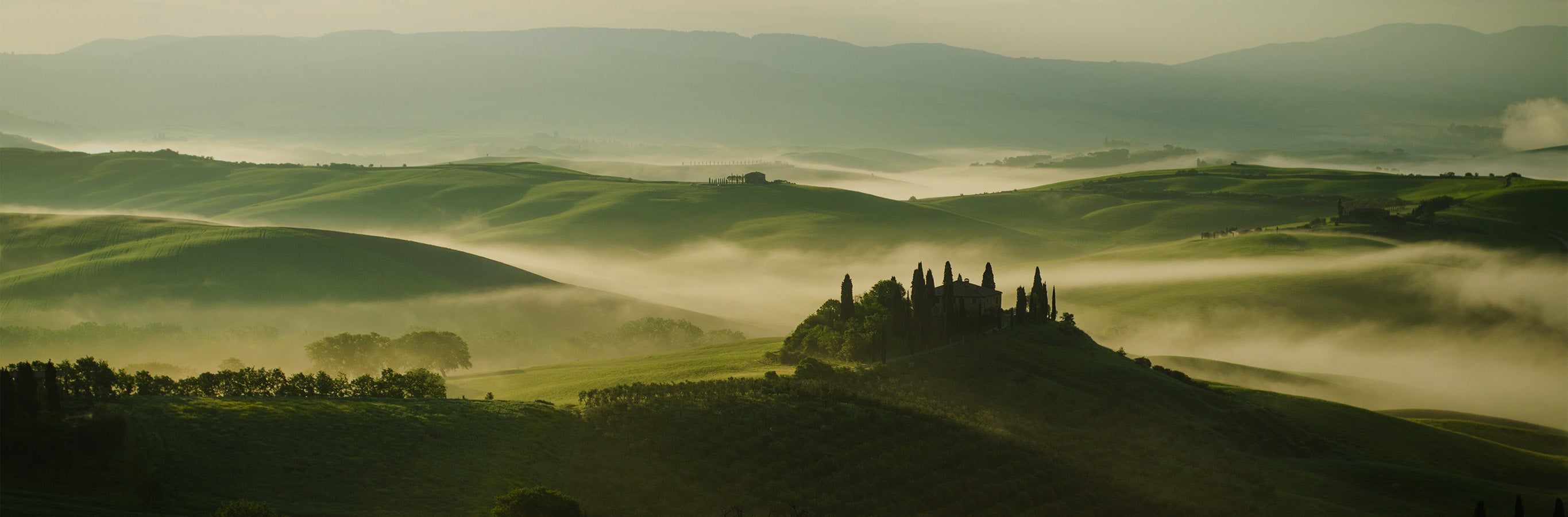 Misty morning light through hills, reflecting the soft glow of Sandra semi-sheer curtains.